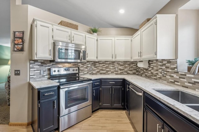 108 Serenity Cir, Buffalo, MN 55313 - kitchen with stainless steel appliances, white cabinets, a sink, light stone countertops, and light wood-type flooring