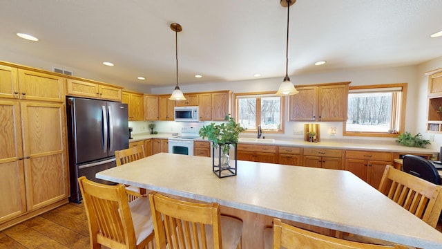 kitchen featuring a sink, recessed lighting, a kitchen breakfast bar, and white appliances