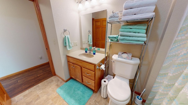 full bath with vanity, baseboards, and toilet