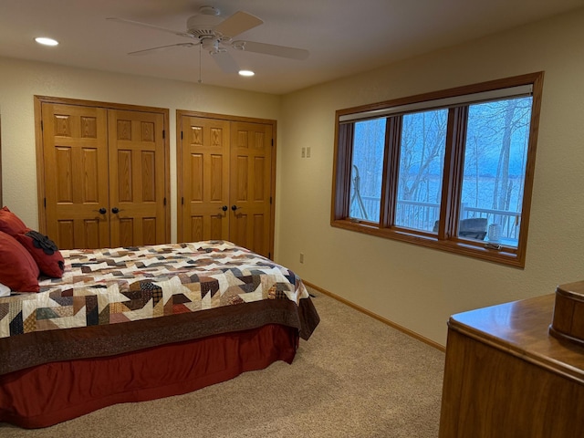 carpeted bedroom with two closets, recessed lighting, baseboards, and ceiling fan