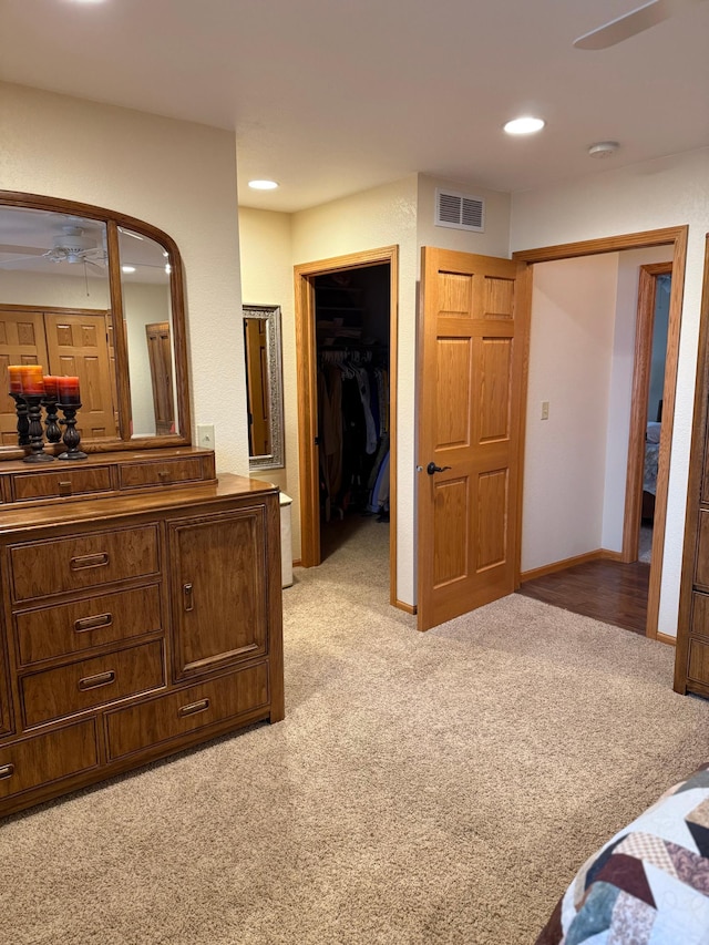bedroom with visible vents, a closet, light carpet, a walk in closet, and recessed lighting