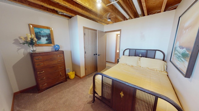bedroom featuring baseboards, a closet, and light colored carpet