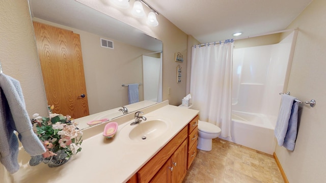 full bath with stone finish floor, shower / bath combination with curtain, visible vents, vanity, and toilet