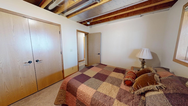 bedroom featuring a closet, carpet, and beam ceiling