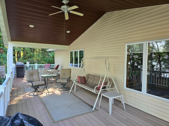 wooden terrace with a ceiling fan and a grill