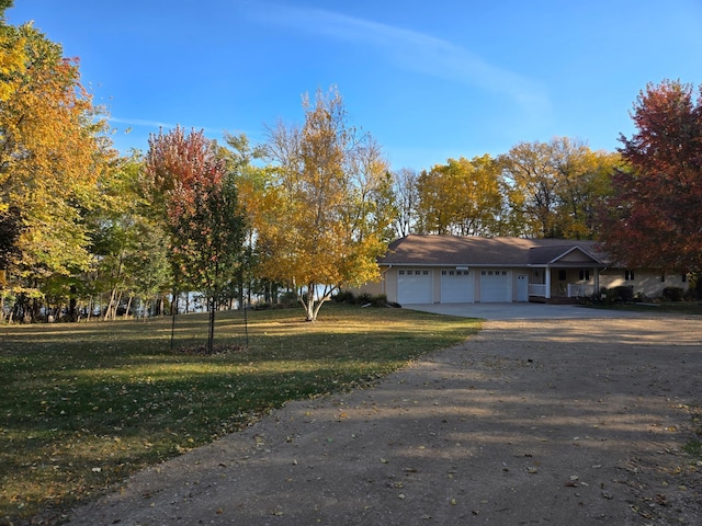 view of side of property with a lawn, an attached garage, and concrete driveway