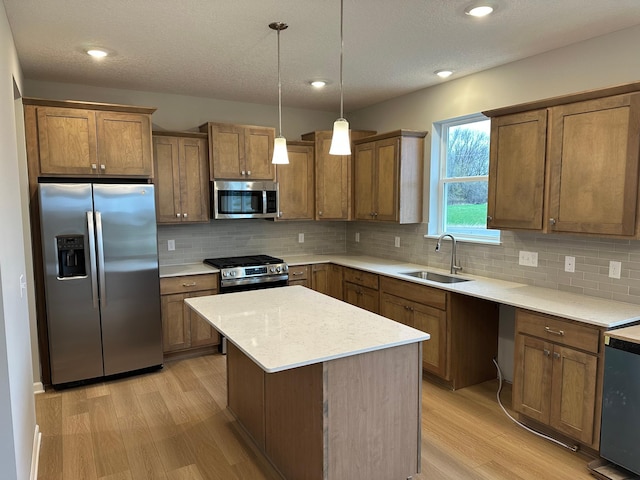 kitchen with a sink, backsplash, stainless steel appliances, and light wood-style floors