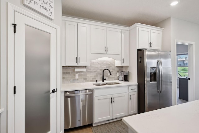 kitchen with light countertops, a sink, white cabinets, and stainless steel appliances