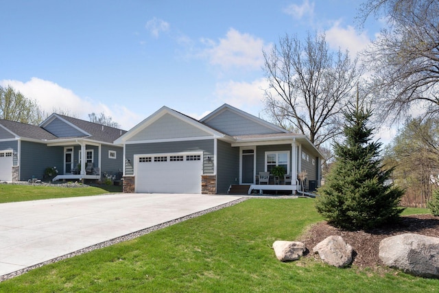 craftsman house with an attached garage, stone siding, a porch, a front yard, and driveway