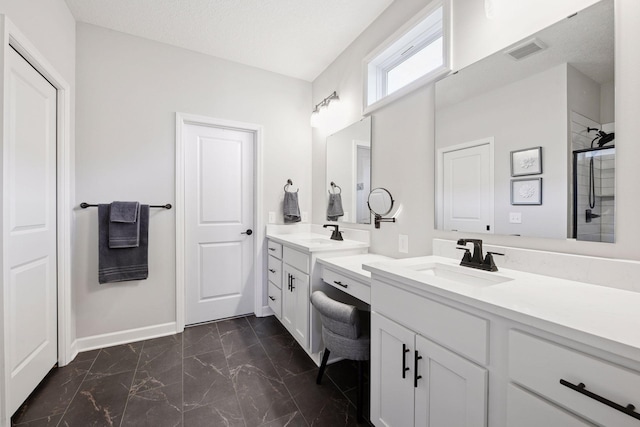 bathroom with visible vents, two vanities, a sink, baseboards, and marble finish floor