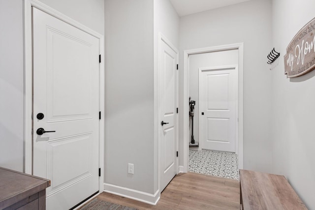 doorway featuring light wood-style floors and baseboards