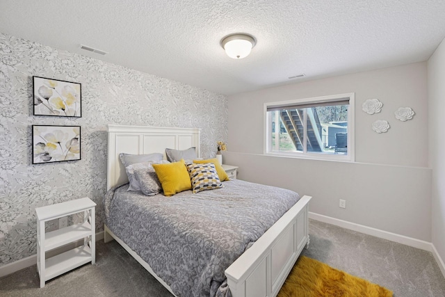 bedroom featuring a textured ceiling, wallpapered walls, baseboards, and carpet