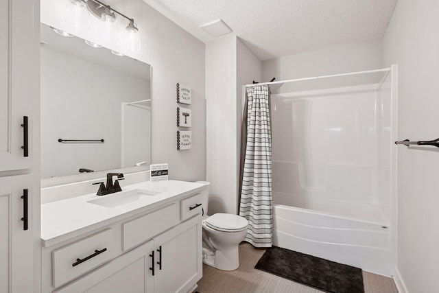 full bath featuring vanity, a textured ceiling, shower / bathtub combination with curtain, and toilet