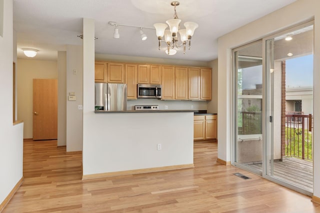 645 1st St Unit 411, Minneapolis, MN 55401 - kitchen featuring stainless steel appliances, light wood finished floors, light brown cabinets, and a chandelier
