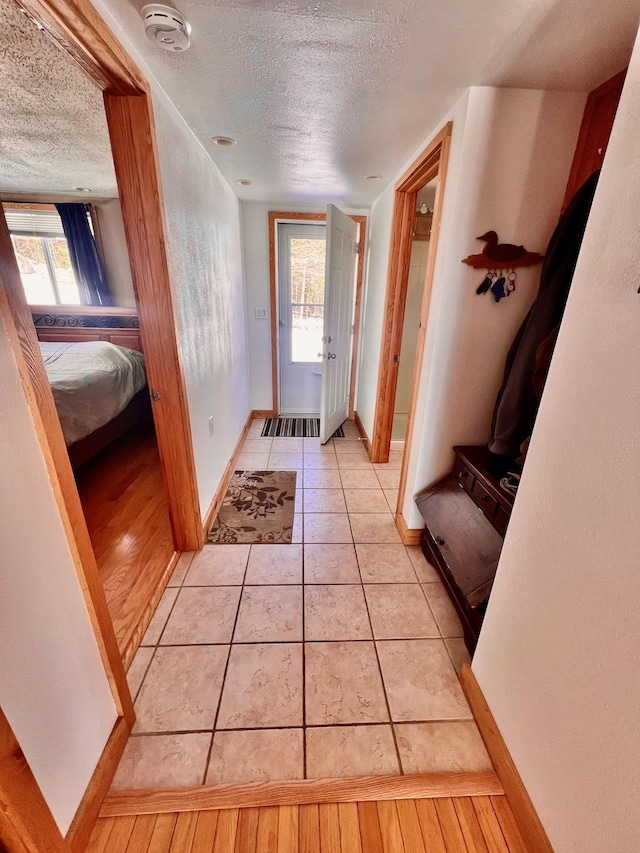 4832 Ambassador Point Ct, Leiding Twp, MN 55771 - doorway to outside with a textured ceiling, plenty of natural light, light tile patterned floors, and baseboards