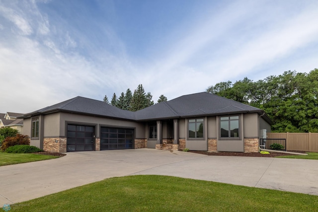 4109 66th St S, West Fargo, ND 58104 - prairie-style home with stone siding, an attached garage, driveway, and stucco siding