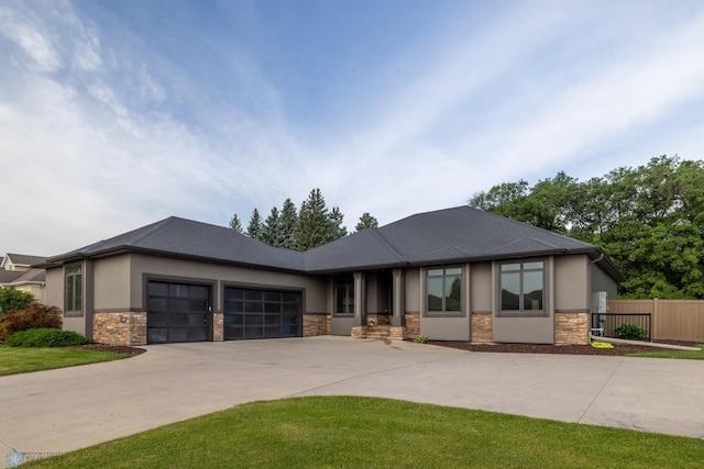 4109 66th St S, West Fargo, ND 58104 - prairie-style house featuring stone siding, an attached garage, concrete driveway, and stucco siding