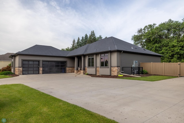4109 66th St S, West Fargo, ND 58104 - view of front facade with stone siding, an attached garage, concrete driveway, and stucco siding
