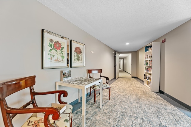 carpeted dining space with a textured ceiling and baseboards