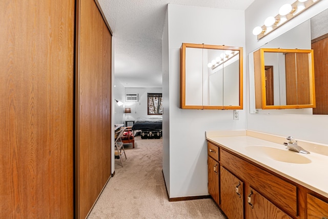 ensuite bathroom featuring ensuite bath, vanity, a textured ceiling, and a wall unit AC
