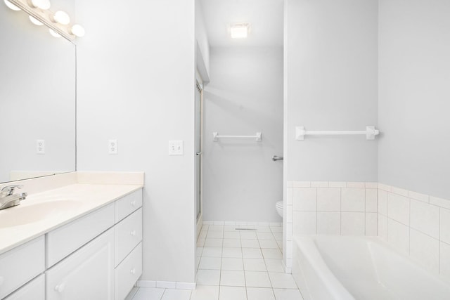 full bath with vanity, toilet, tile patterned floors, baseboards, and a garden tub
