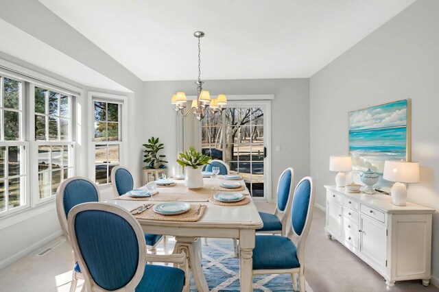 dining area with an inviting chandelier, baseboards, visible vents, and light carpet