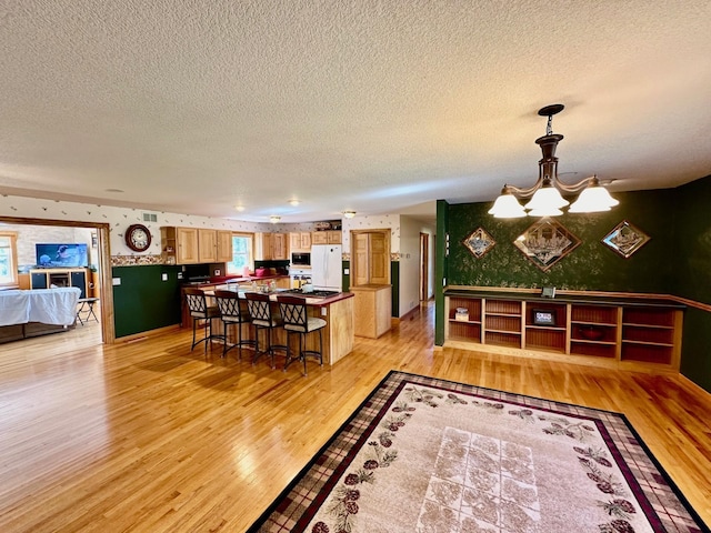 16335 County Road 2, Brainerd, MN 56401 - dining room with light wood-style flooring, a chandelier, a textured ceiling, and wallpapered walls