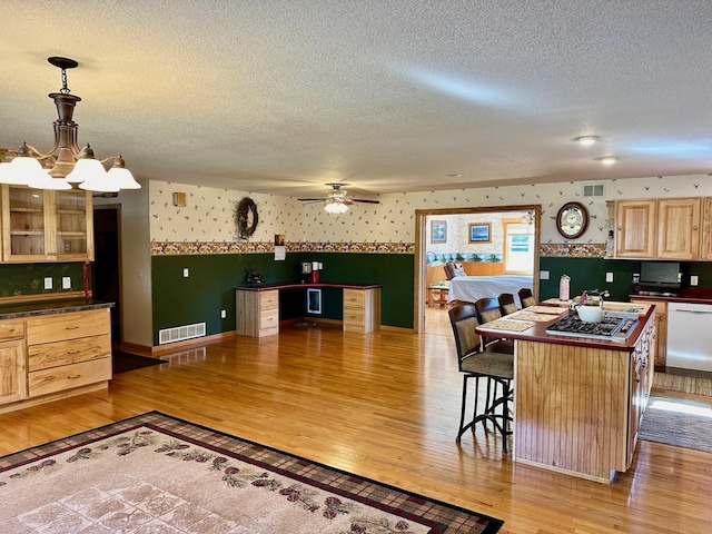 16335 County Road 2, Brainerd, MN 56401 - kitchen with wallpapered walls, dishwasher, light wood-style floors, a textured ceiling, and dark countertops