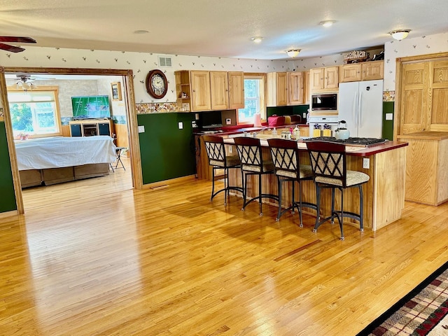 16335 County Road 2, Brainerd, MN 56401 - kitchen featuring freestanding refrigerator, built in microwave, light wood-style floors, light brown cabinets, and a ceiling fan