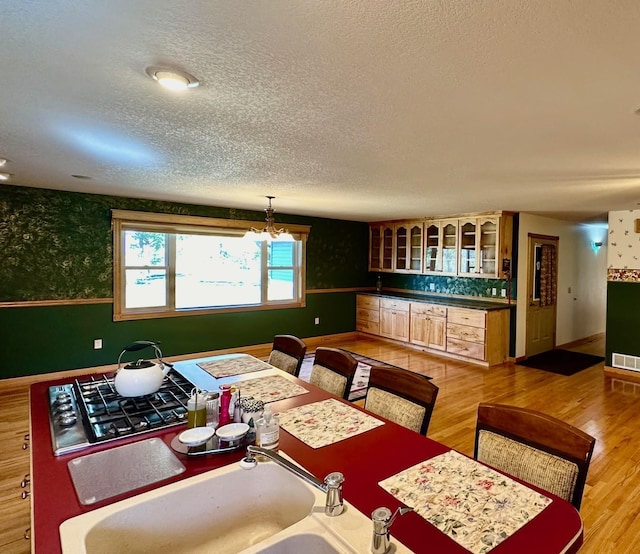 16335 County Road 2, Brainerd, MN 56401 - dining area with wallpapered walls, a textured ceiling, baseboards, and light wood-style floors