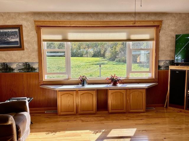 16335 County Road 2, Brainerd, MN 56401 - kitchen with wainscoting, brown cabinets, light wood-style floors, and wood walls