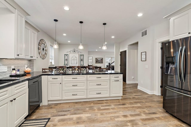 5234 Grand Ave, White Bear Twp, MN 55110 - kitchen with light wood finished floors, a peninsula, dark countertops, visible vents, and fridge with ice dispenser