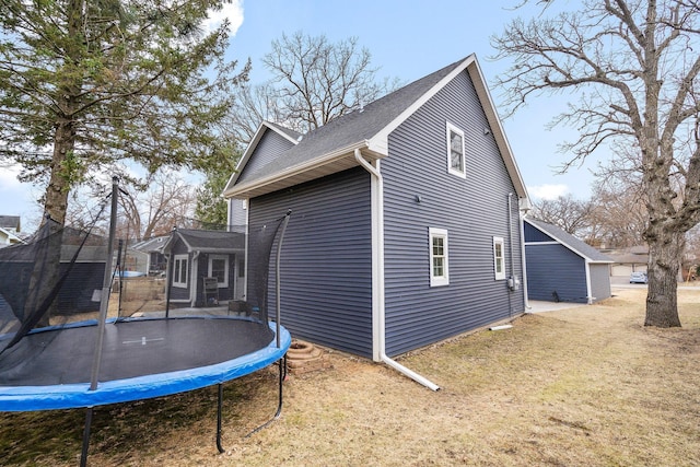 5234 Grand Ave, White Bear Twp, MN 55110 - view of home's exterior with a yard, a shingled roof, and a trampoline