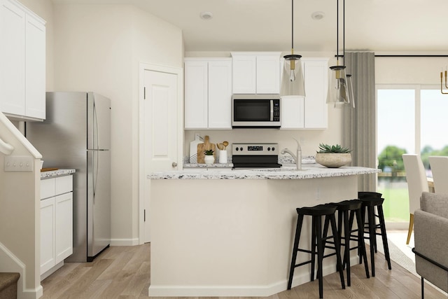 kitchen with white cabinets, an island with sink, light wood-style flooring, and appliances with stainless steel finishes