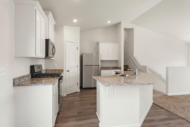 kitchen featuring white cabinetry, a sink, lofted ceiling, stainless steel appliances, and dark wood-style floors