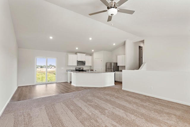 unfurnished living room with a ceiling fan, recessed lighting, light carpet, lofted ceiling, and baseboards