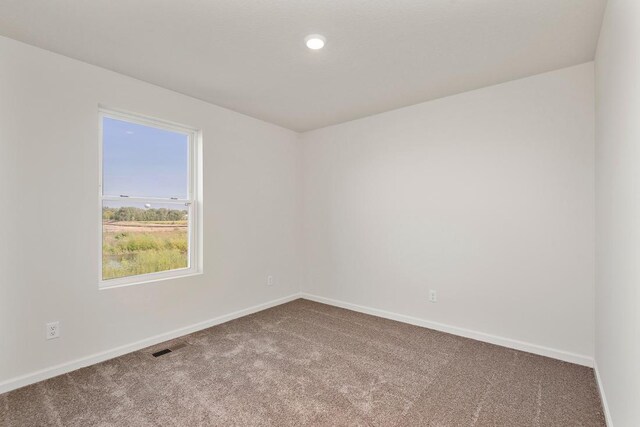 empty room with baseboards and carpet