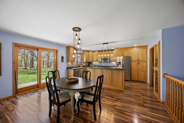 dining room featuring dark wood-style floors, baseboards, and a textured ceiling