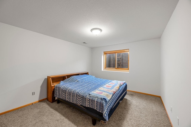 carpeted bedroom featuring baseboards and a textured ceiling