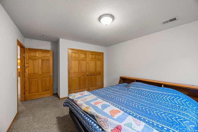 carpeted bedroom with a closet, a textured ceiling, and baseboards
