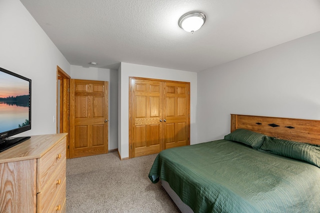 bedroom with a closet, light colored carpet, and baseboards