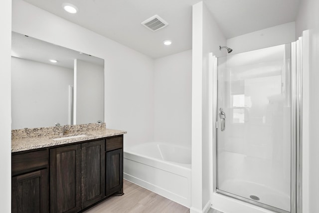 521 Douglas Dr S, Annandale, MN 55302 - bathroom with wood finished floors, a garden tub, a stall shower, vanity, and recessed lighting