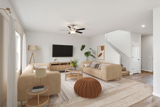 living room with baseboards, a ceiling fan, recessed lighting, wood finished floors, and stairs