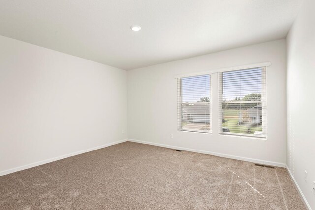 empty room with baseboards and carpet flooring