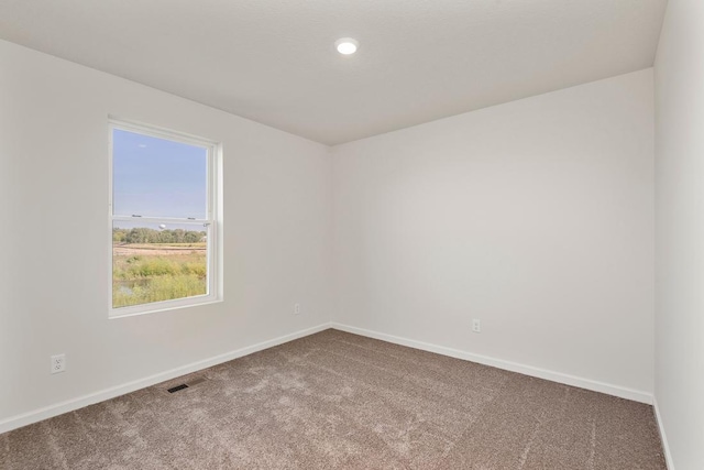 empty room with baseboards and carpet