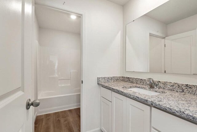 bathroom with vanity, shower / washtub combination, and wood finished floors