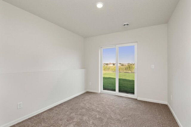 empty room with baseboards and carpet
