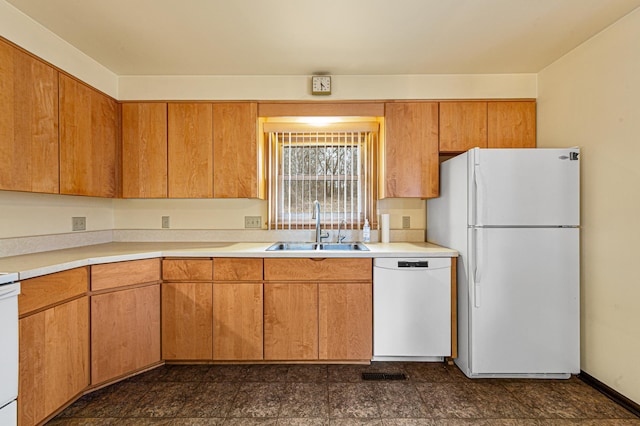 kitchen with light countertops, a sink, visible vents, and white appliances