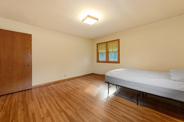 unfurnished bedroom featuring light wood finished floors and baseboards