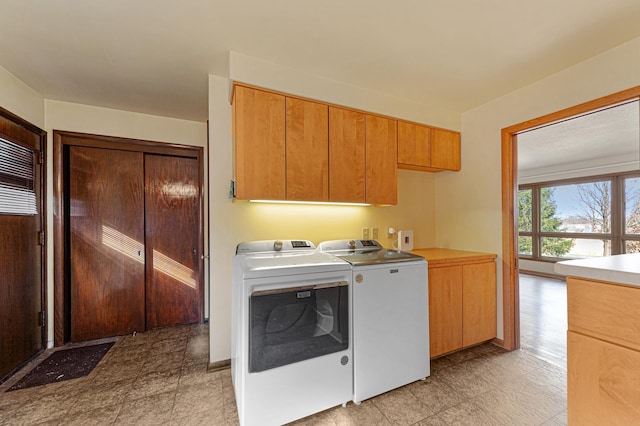 laundry room featuring washing machine and clothes dryer and cabinet space